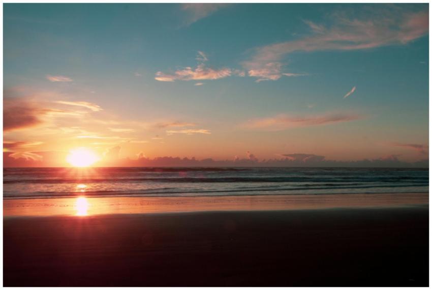 A tranquil beach sunset with vivid colors reflecti