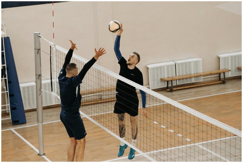 Two male athletes playing a competitive volleyball