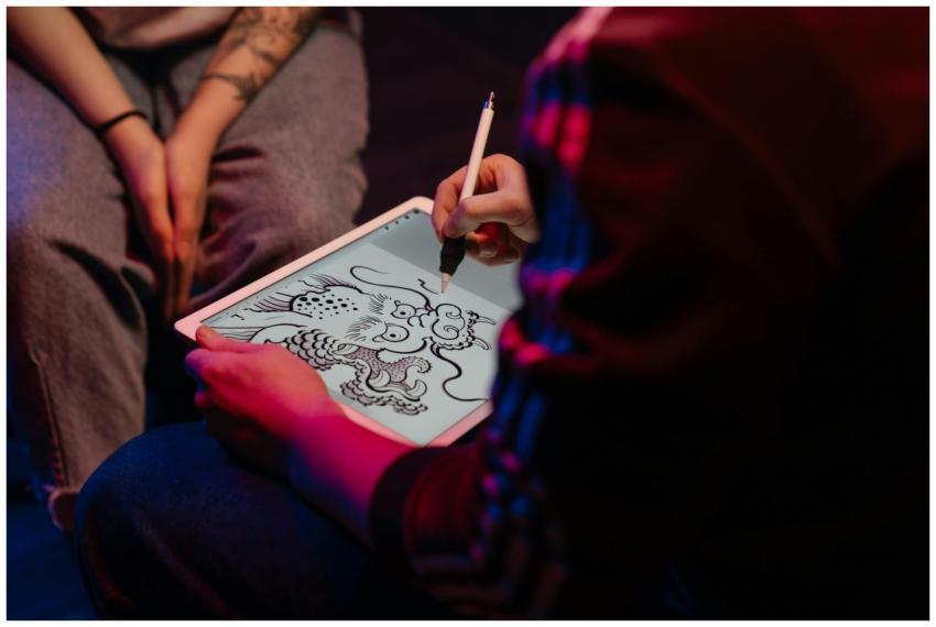 Artist creating a digital dragon tattoo design on