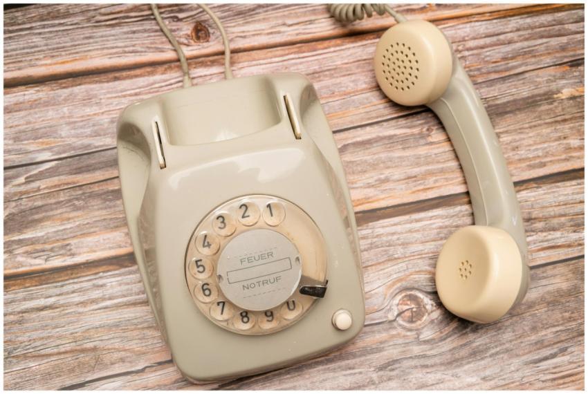 Classic rotary dial telephone on rustic wooden bac