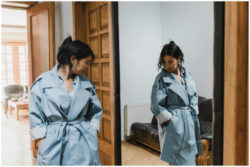 Stylish woman in blue trench coat looking at her r