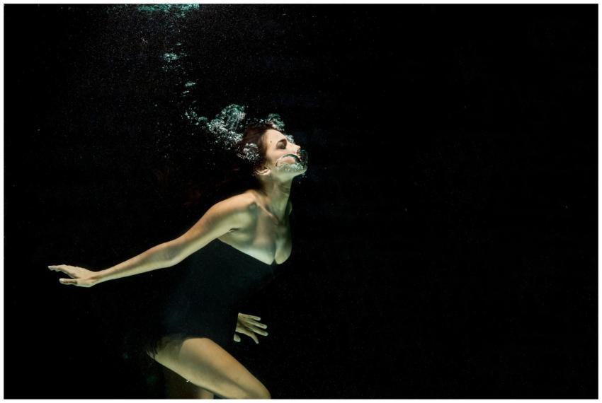 Artistic underwater shot of a woman in black dress