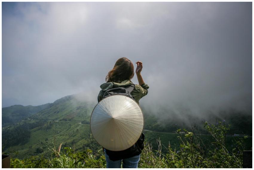 Back view of a woman traveler in misty mountains w