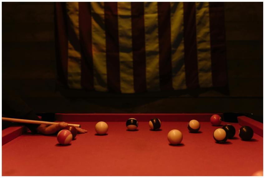 Moody indoor scene of a billiards game in progress