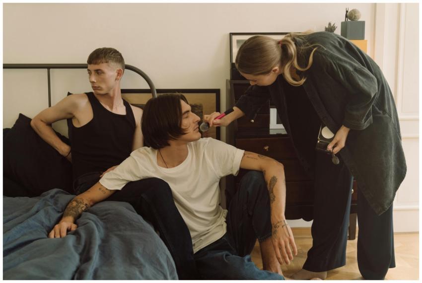 A makeup artist applies makeup to a man in a relax