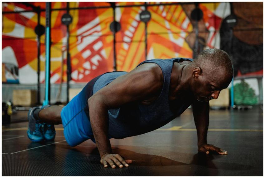 Adult man doing push-ups in a colorful gym setting