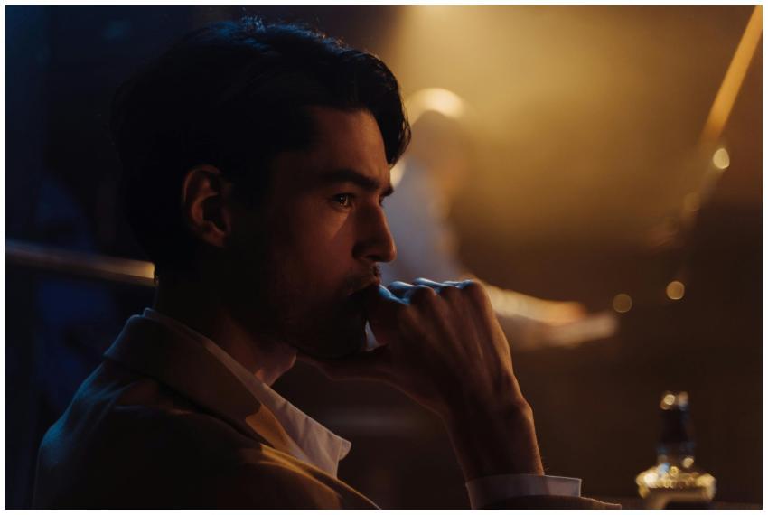 A thoughtful man gazing afar, hand on chin, in a m