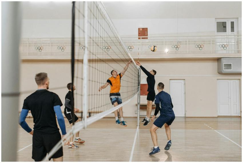 Exciting indoor volleyball match with athletes jum