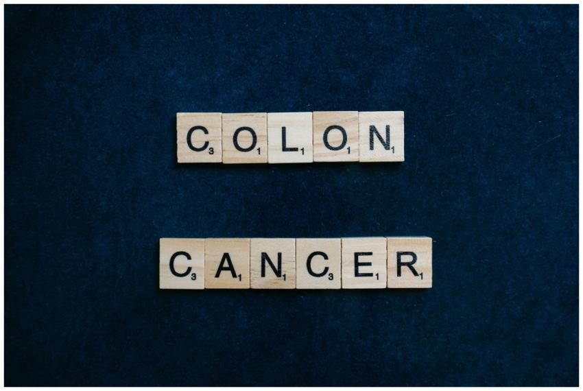Wooden Scrabble tiles spelling 'Colon Cancer' on a