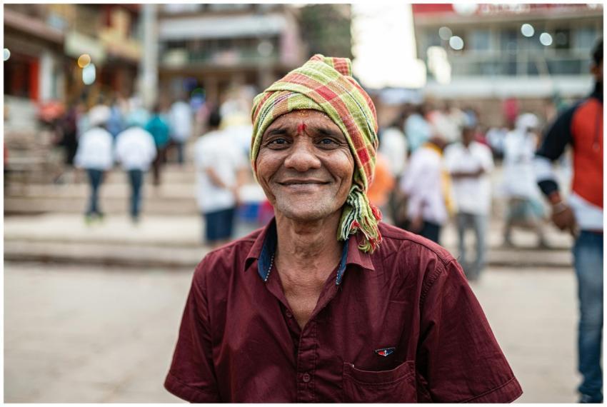 A joyful man in traditional attire smiles warmly i