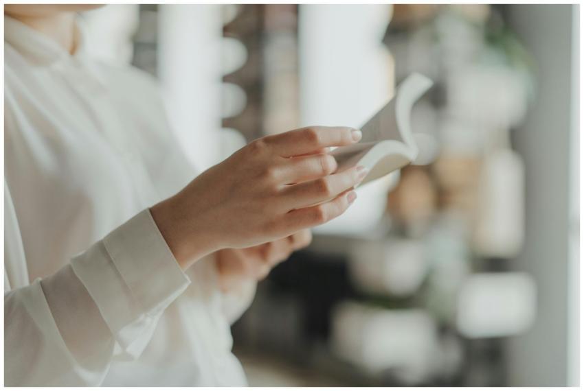 Hands holding and flipping through a book with a s