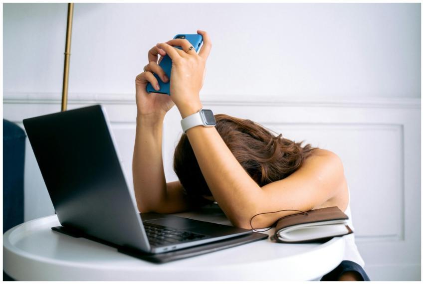 A woman overwhelmed by work, resting head on table