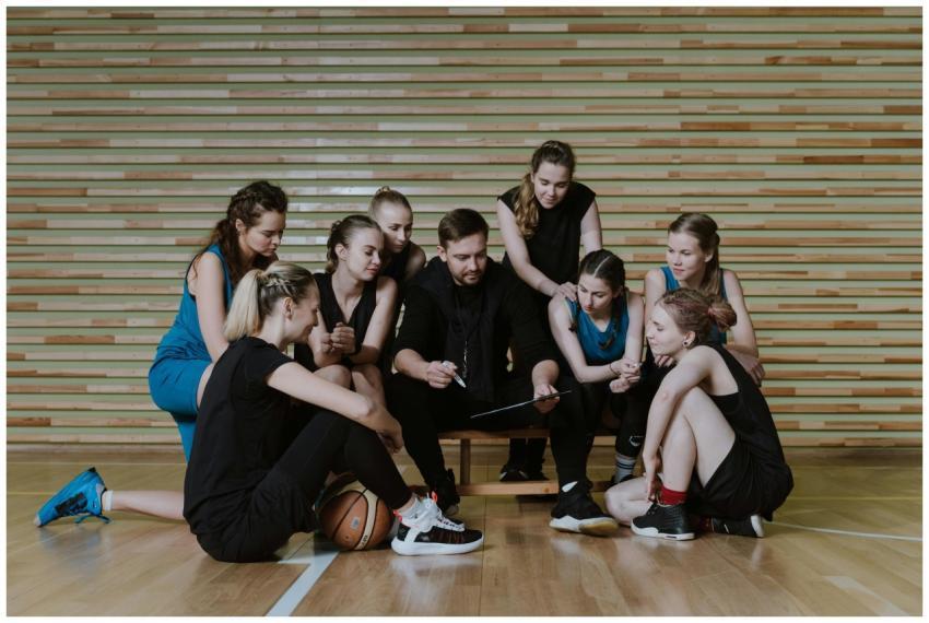 A coach strategizes with a women's basketball team