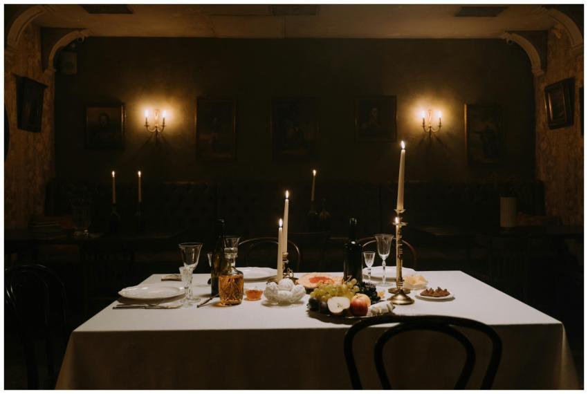 A dimly lit dining room with elegantly set table,