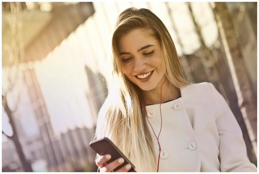 Happy woman listening to music on her smartphone w