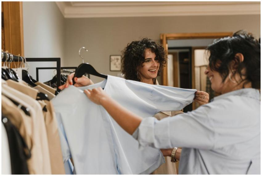 Two women cheerfully shopping for clothes in a fas
