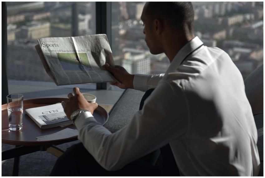 Businessman in office reading sports section, enjo
