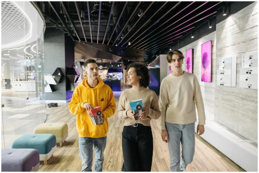 Group of friends walking with popcorn at a modern