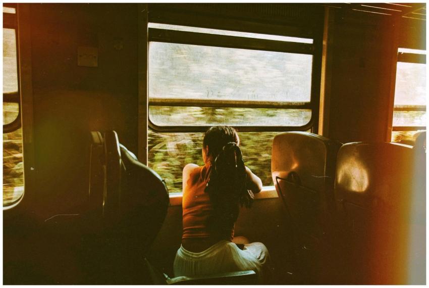 A woman gazes out of a train window, enjoying a se