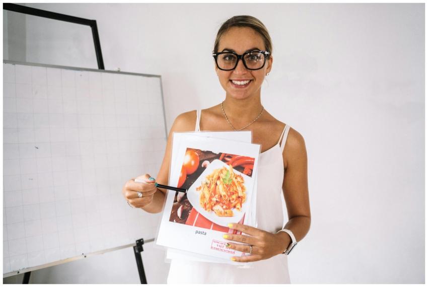 A teacher in a classroom holding a food illustrati