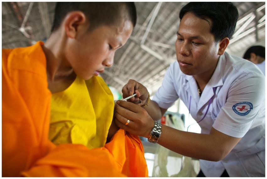 A healthcare worker vaccinates a young boy wearing