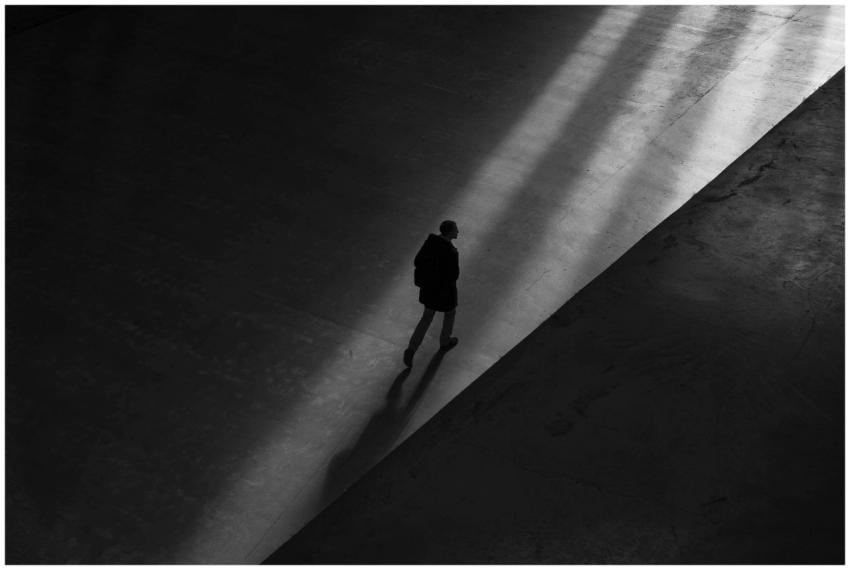 Black and white photo of a man walking through sha