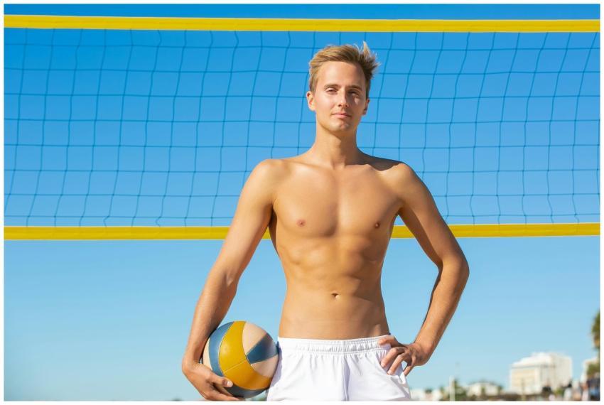 Athletic shirtless man posing with volleyball on a