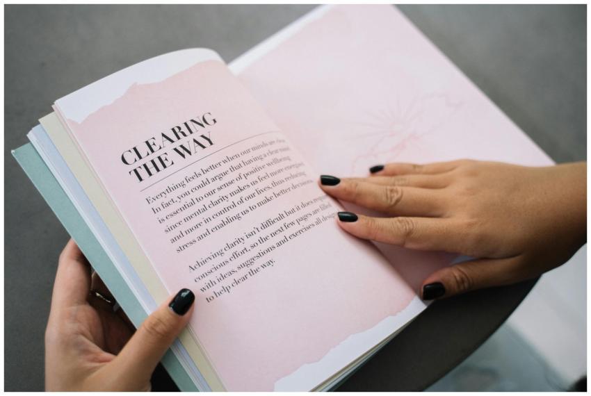 Hands flipping through a motivational book indoors