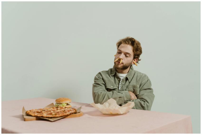 Bearded man with playful expression sitting at tab