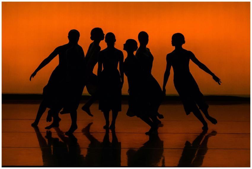 Silhouetted dancers performing contemporary ballet