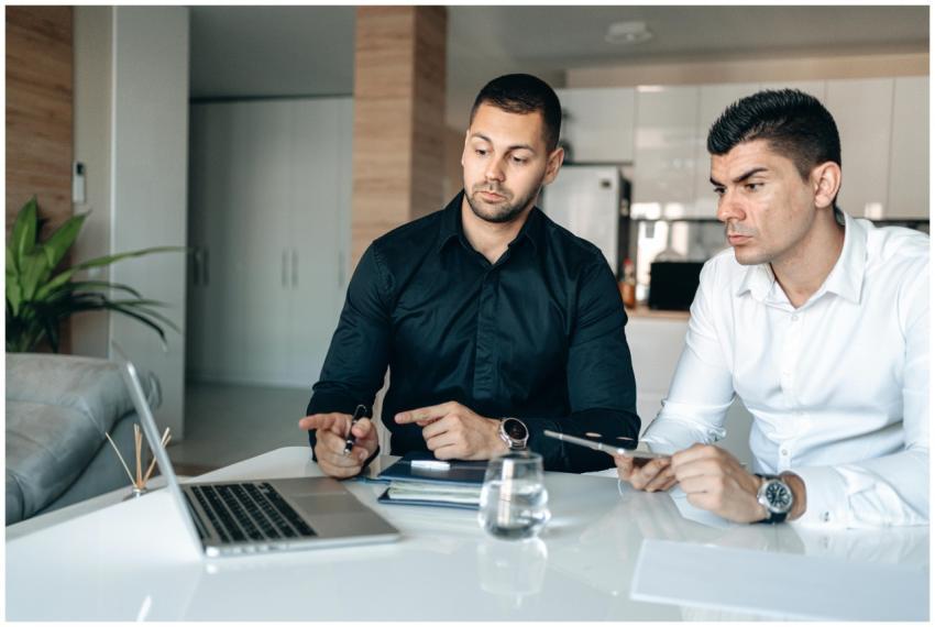 Two men in a modern office engaged in business col