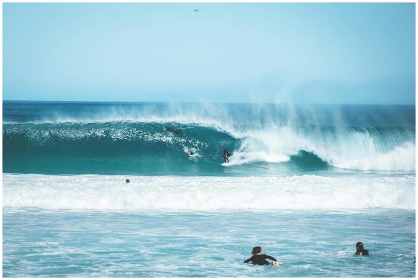 Surfers enjoy riding waves in a tropical ocean set