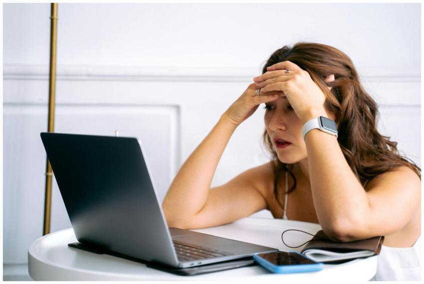 Woman feeling stressed while working on a laptop,
