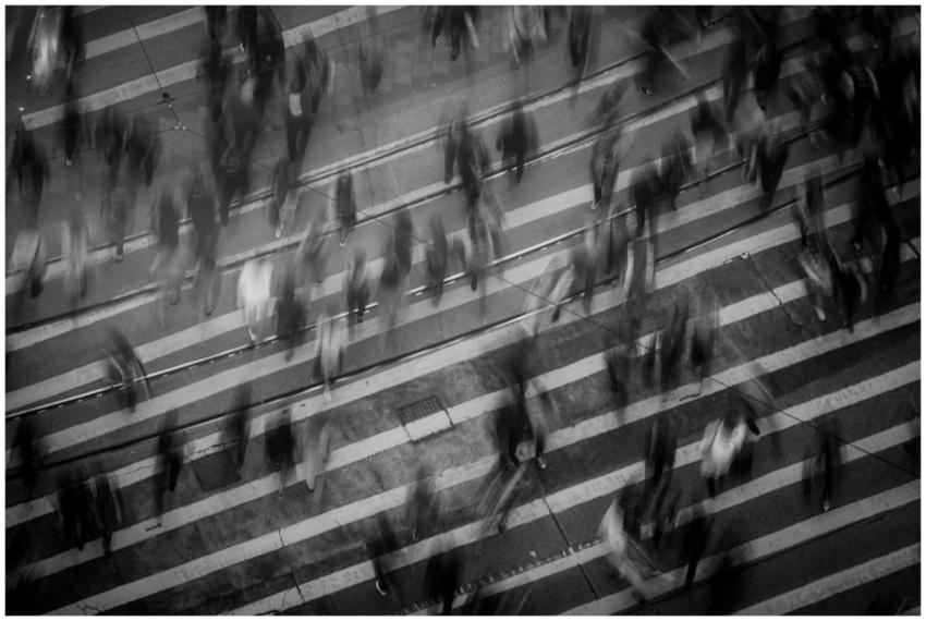 Blurred pedestrians crossing a busy Hong Kong stre
