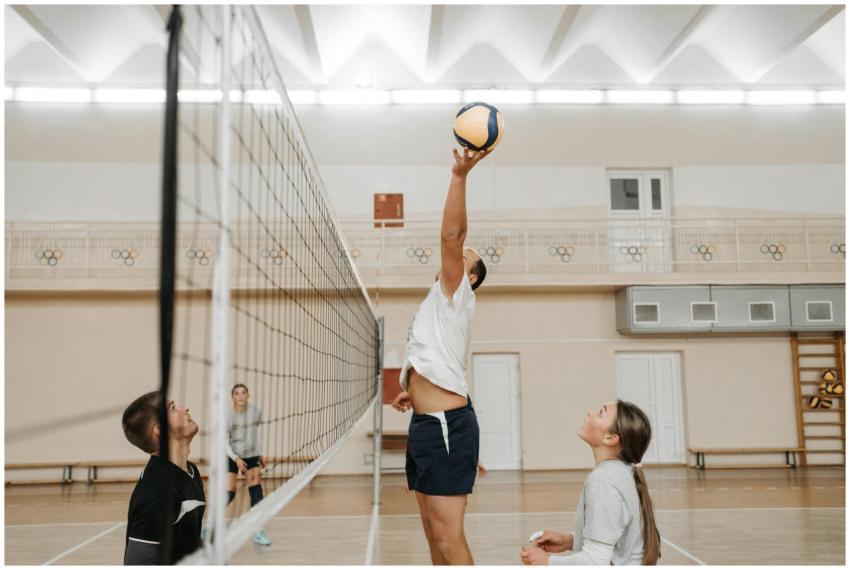Three players engage in an intense volleyball matc