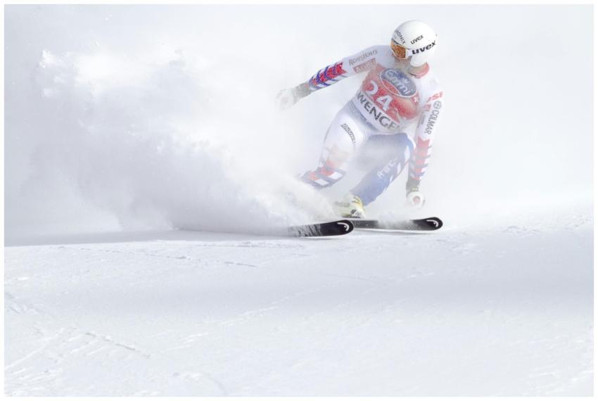 A skier in motion navigating a snowy slope with sp