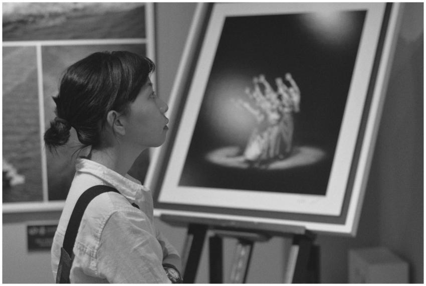 A woman gazing at a black and white painting in an
