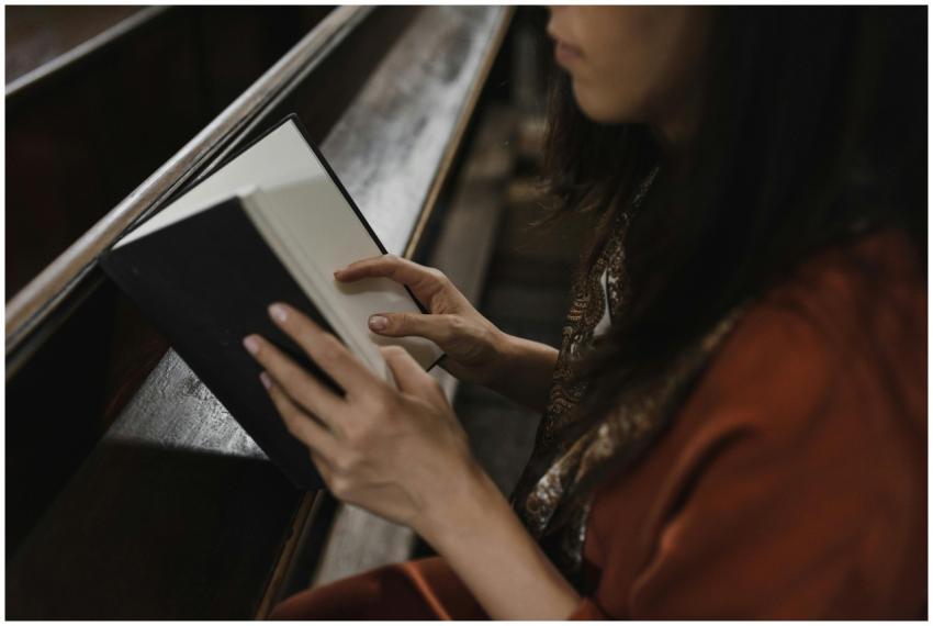 A woman sitting in a church pew, deeply focused on