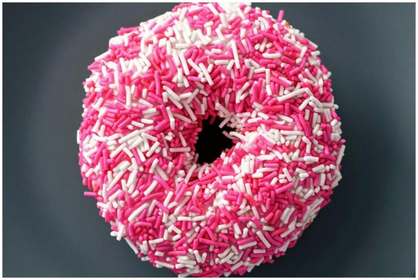 Close-up of a donut covered in pink and white spri