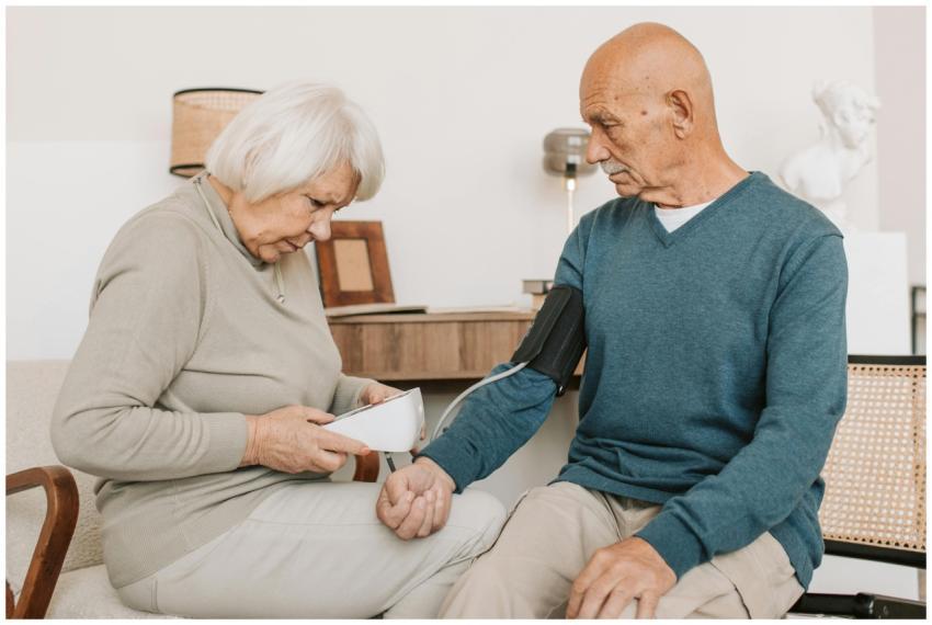 An elderly couple measuring blood pressure with a