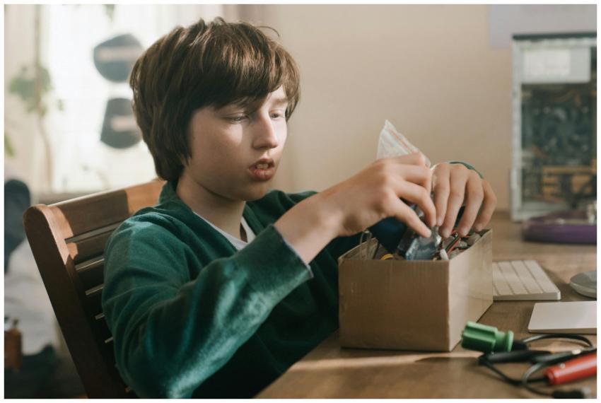 Young boy focused on exploring electronics compone