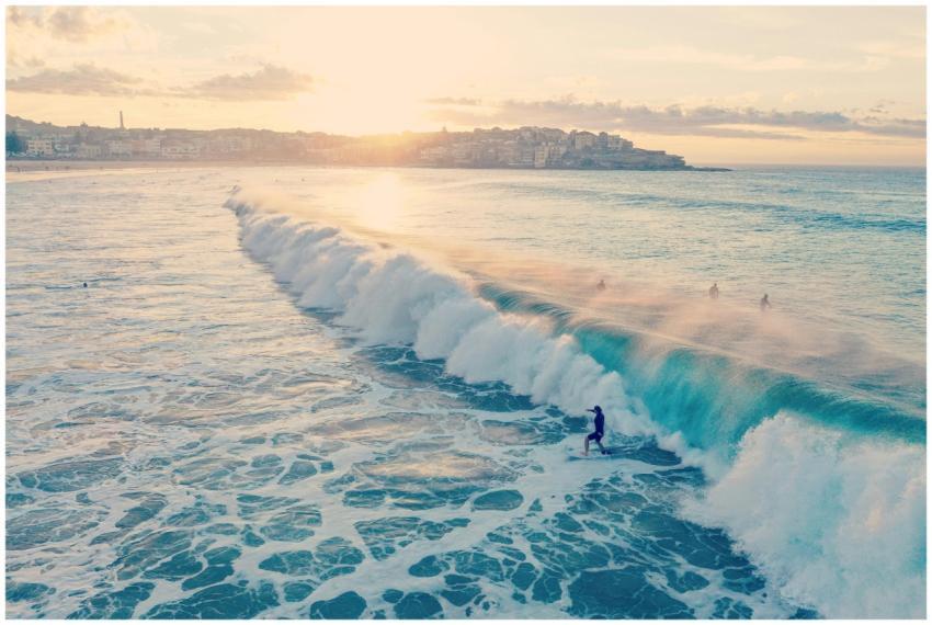 Surfers ride waves at Bondi Beach during a beautif