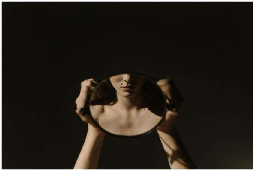 Artistic portrait of a woman holding a mirror, ref