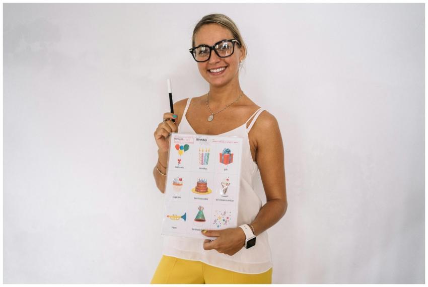 Woman holding a birthday-themed educational poster