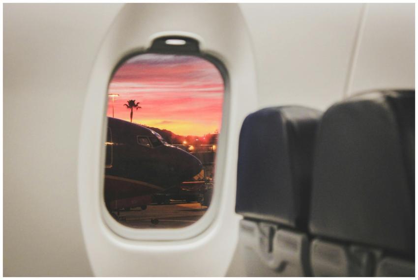 Scenic sunset view through airplane window with pl