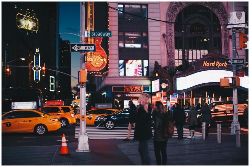 A bustling street view of Broadway at night featur