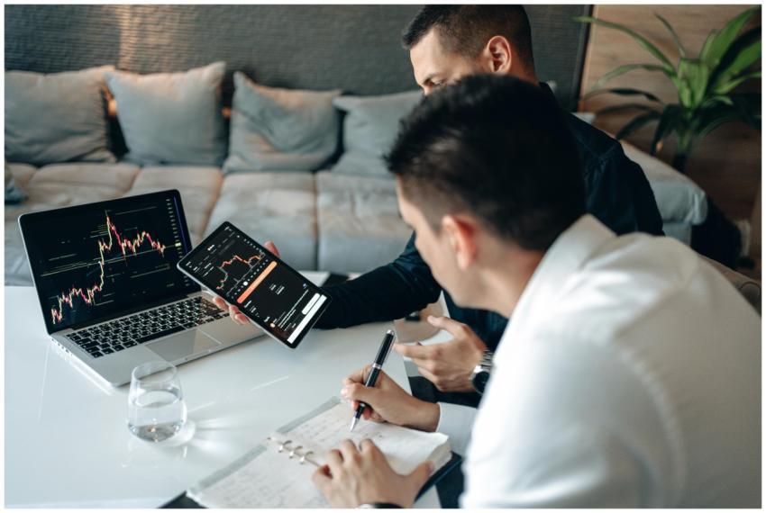 Two men discussing market trends using a tablet an