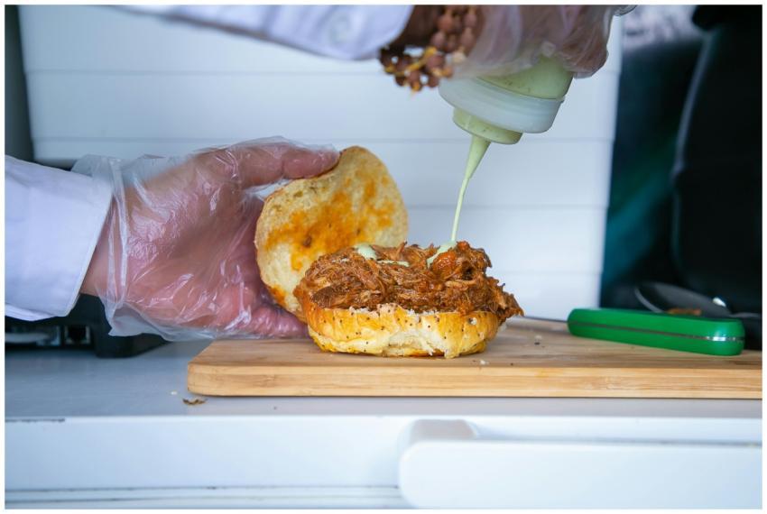 Crop anonymous male cook pouring mayonnaise sauce