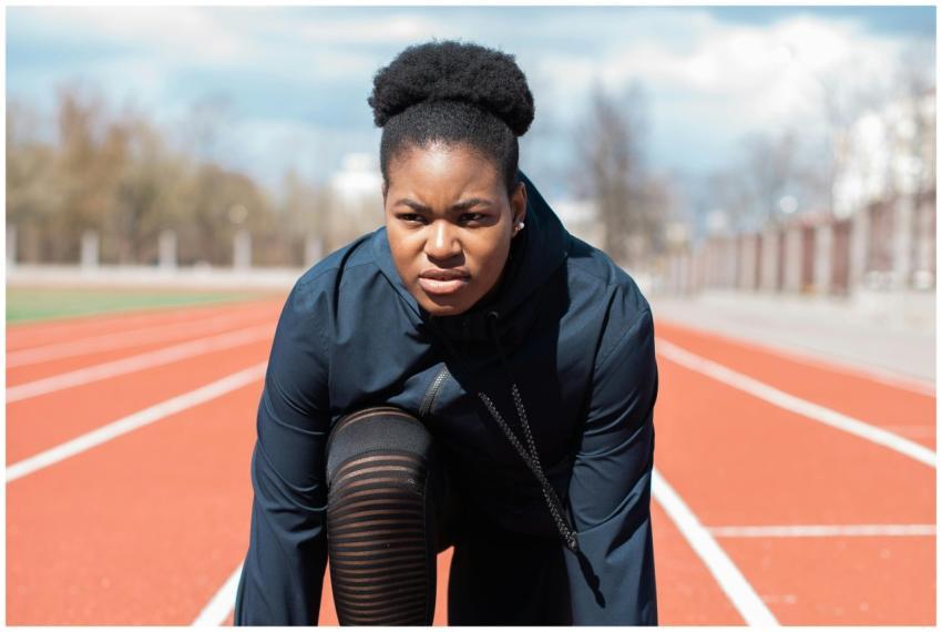 A determined woman in athletic gear prepares to ru