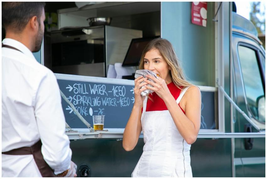 Calm woman in stylish clothes standing near food t